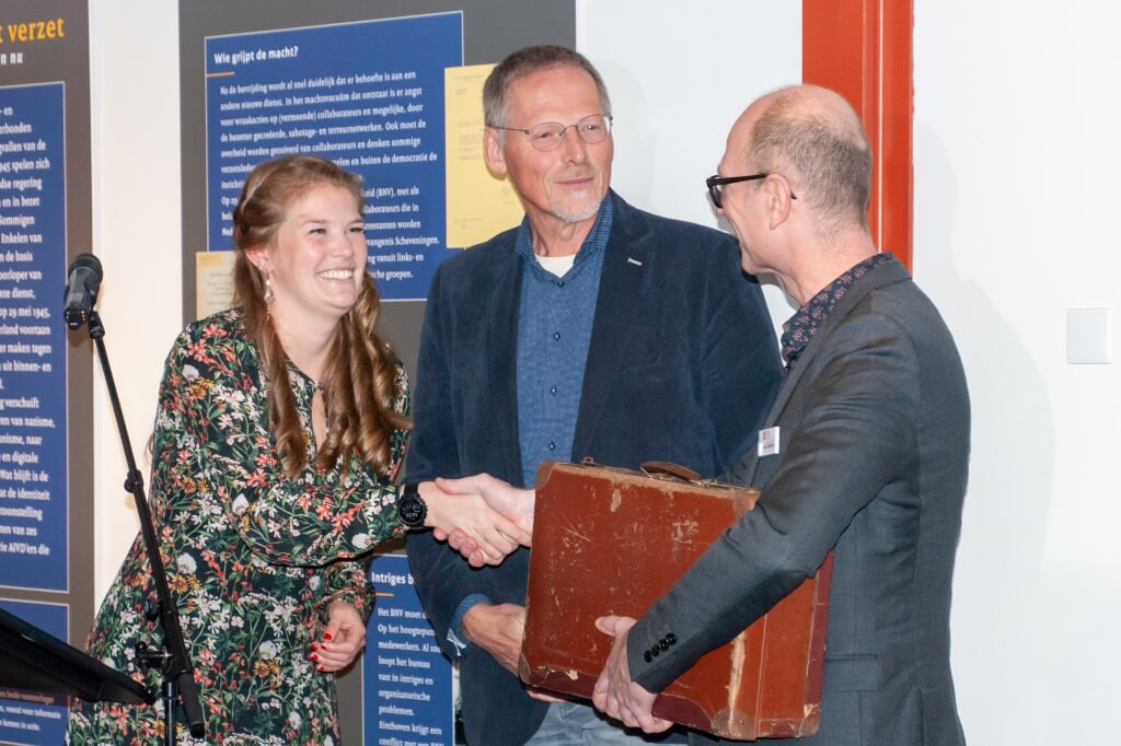Annemiek Lely en haar vader Johan overhandigen de koffer van Tom Navis aan de directie van verzetsmuseum Het Oranjehotel.