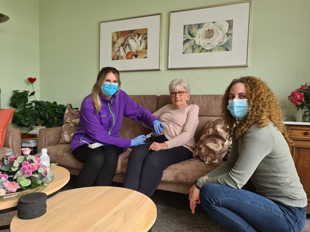 Oncologieverpleegkundige Bibi Muller geeft mevrouw Arendse voor het eerst thuis haar chemo-injectie. Kirsten Schoenmaker van Alrijne Ziekenhuis draagt de zorg met een gerust hart over.
