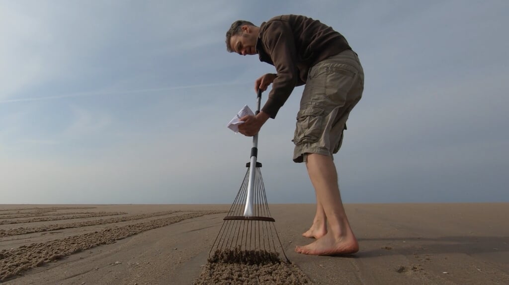 Gert-Jan van der Kooij, 'De Krijtman', laat zien hoe je strandtekeningen kunt maken op het natte zand.