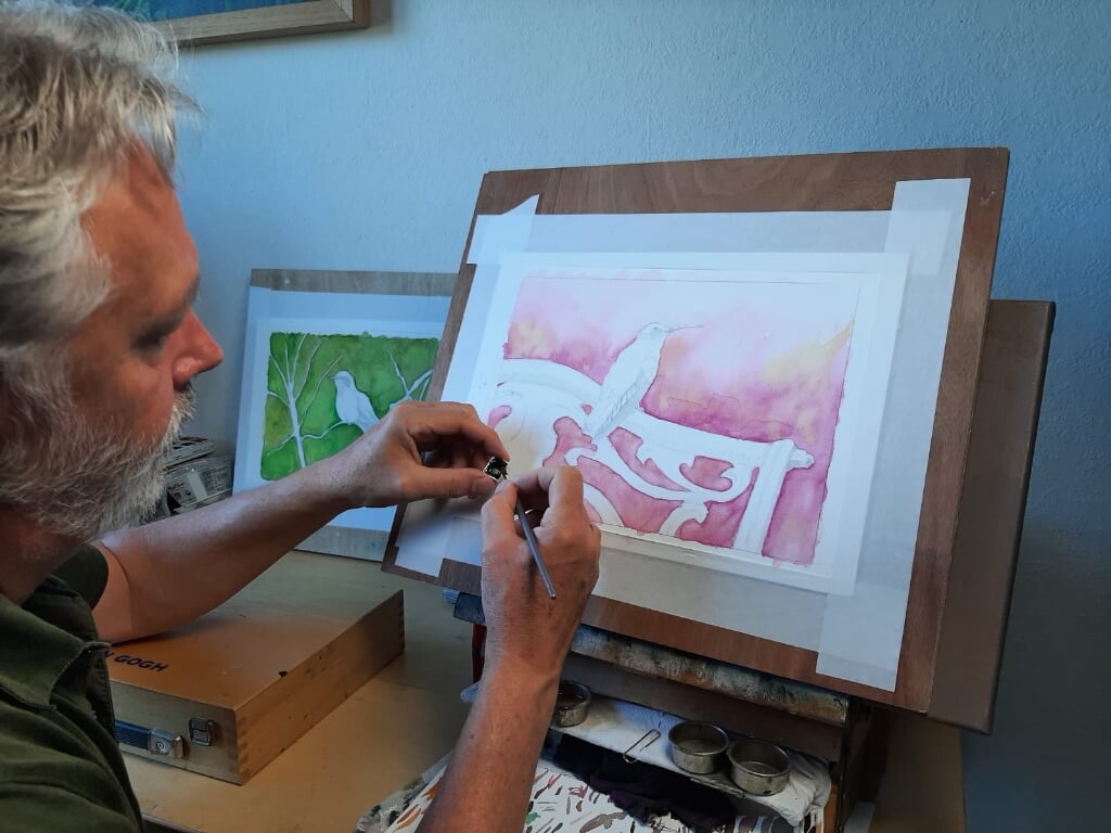 Michel werkt aan een aquarel.