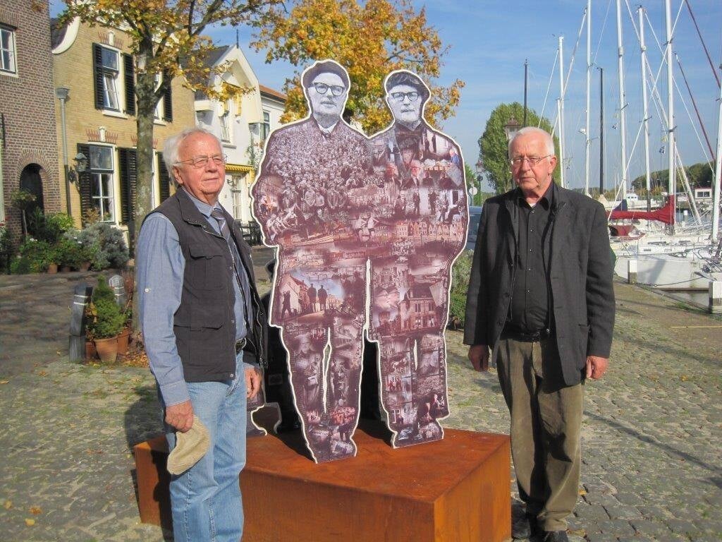 Jan Maneij en zijn broer, de Rotterdamse schrijver Rien Vroegindeweij, bij een beeld van de beroemde broers Boomsma in hun geboorteplaats Middelharnis.