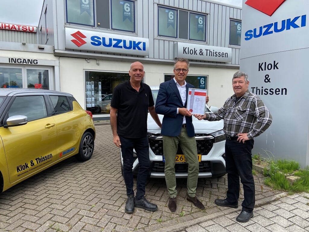 Jan Klok en Sef Thissen van automobielbedrijf Klok & Thissen ontvangen de jubileumoorkonde uit handen van account adviseur BOVAG autodealers, Levien Meiresonne.