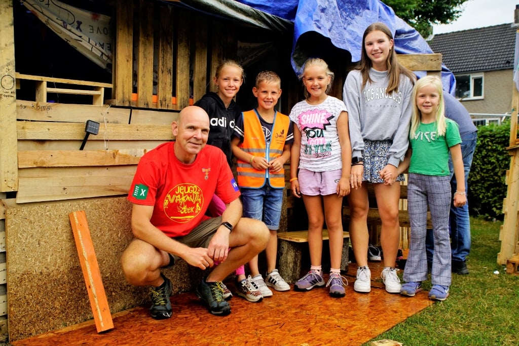 Vrijwilliger Marco met Luuk, Maud, Nika. Sophie en Anouk bij een van de hutten in het huttendorp. 