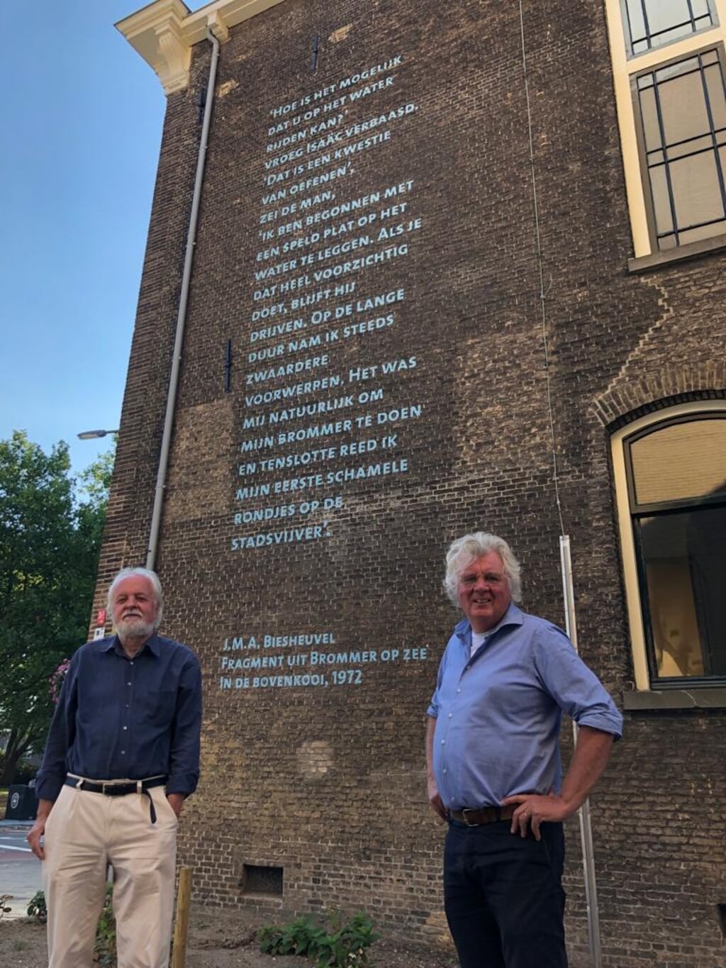 Hans Overheul en Jan van Bergen en Henegouwen zijn blij met het tekstfragment van J.M.A. Biesheuvel aan de muur van het Blauwhuis.