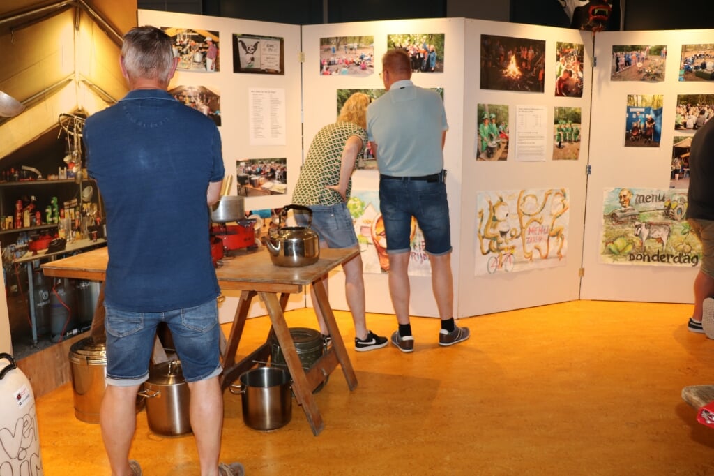 Bezoekers genieten van de groots opgezette expositie over 75 jaar Jeugdwerk. 