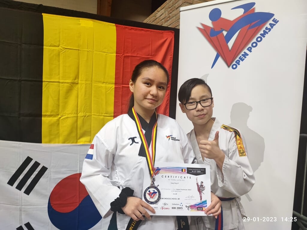 Foto:Ching Yi en Ho Yin met Ching Yi’s zilveren medaille en certificaat van de behaalde prijs.