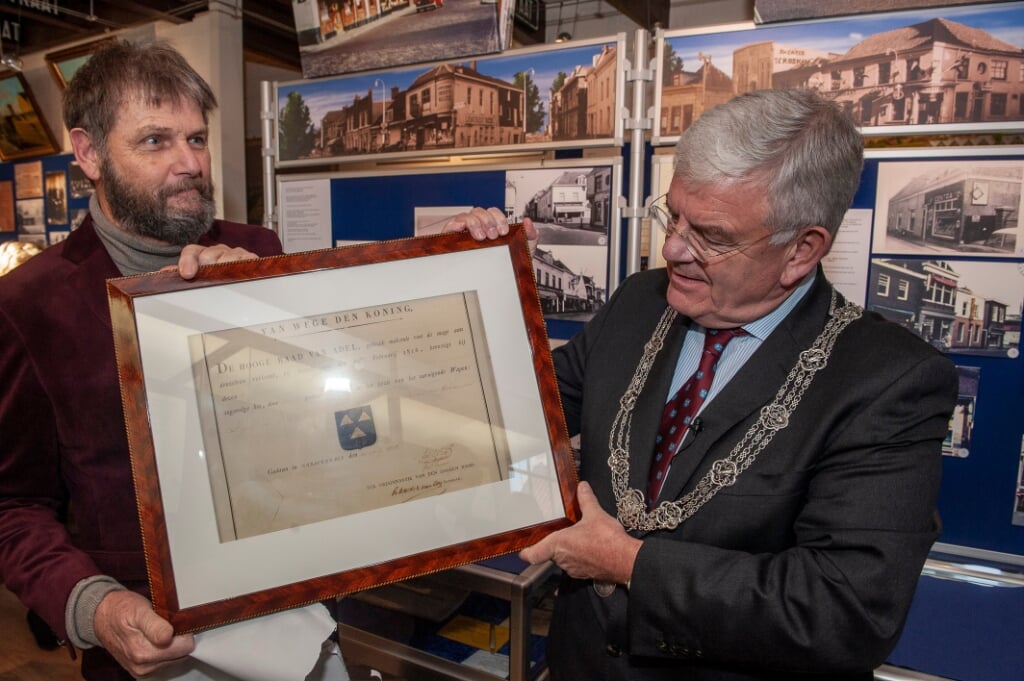 Burgemeester Jan van Zanen (rechts) overhandigt het cadeau van de gemeente Den Haag aan Pjer Wijsman.