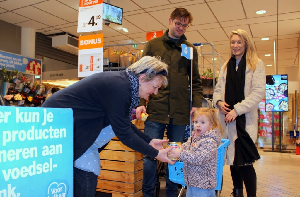 De familie Streefland doet ook mee aan de inzameling voor de Voedselbank. Amarins (2) brengt een blik soep naar vrijwilligster Anneke Pleij.