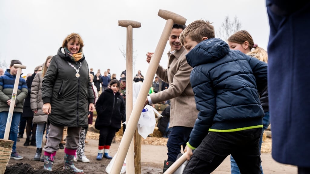 Burgemeester Liesbeth Spies kijkt hoe de kinderen de bomen planten.