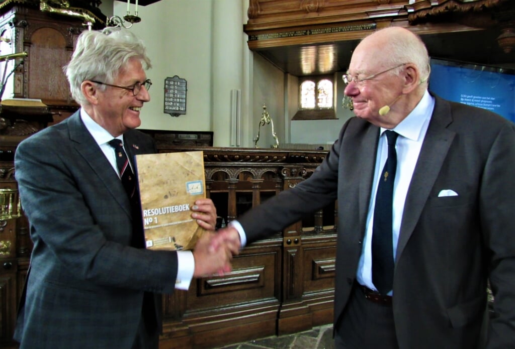 Koos Karssen, voorzitter PGM, kreeg van auteur Geb van Doornik het eerste exemplaar van het Eerste Resolutieboek.