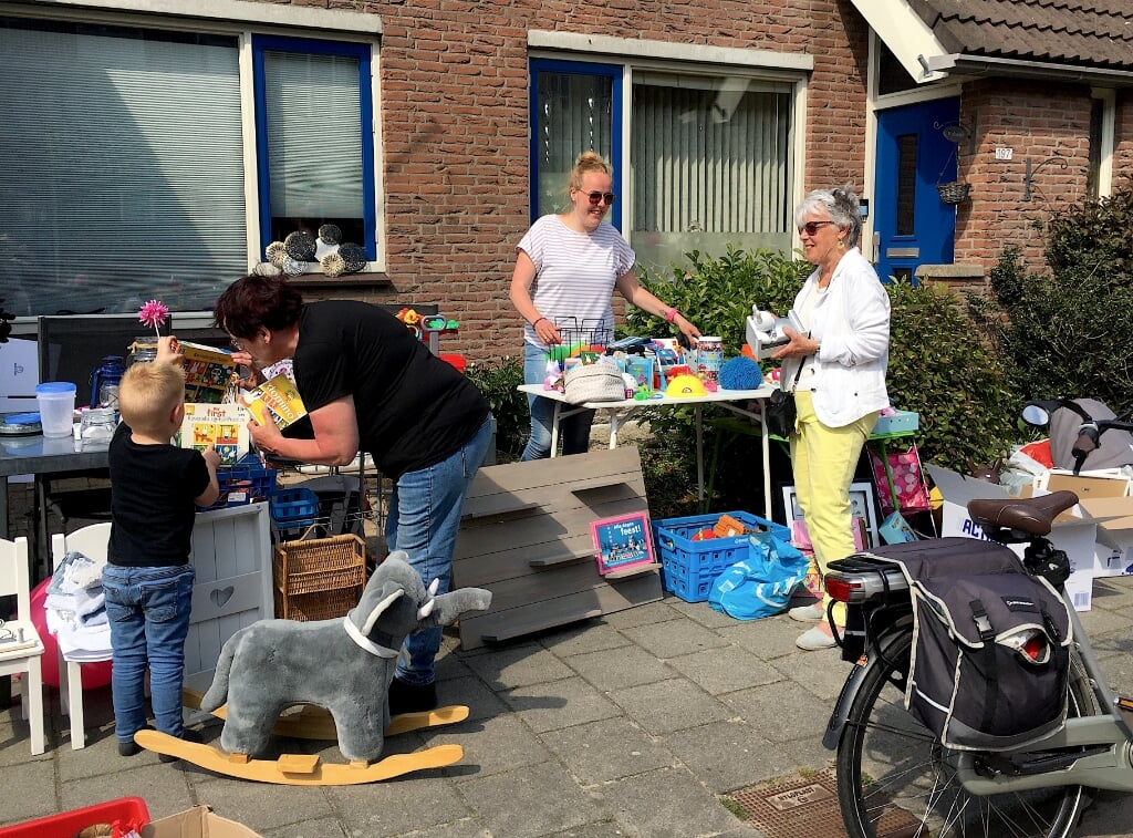 Michelle Poldermans (midden) verkoopt Nijntje-spullen aan Ank Verheul. Links Tineke Poldermans met kleinzoon Joey.