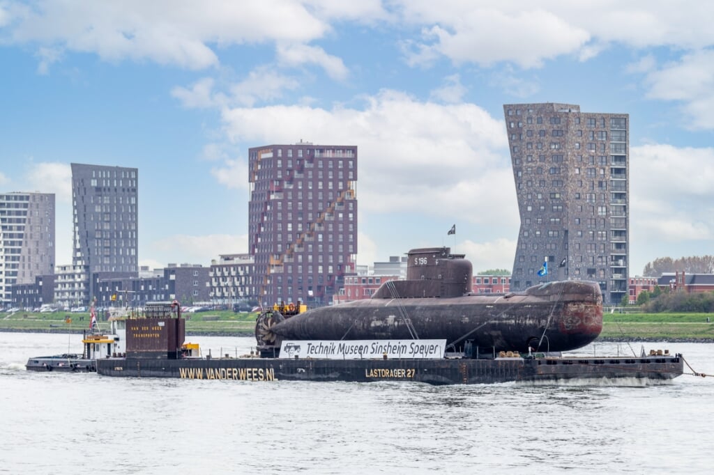 Van der Wees vervoert de U-17 op een ponton naar Rotterdam voor een fotosessie. Hier passeert de onderzeeër Rozenburg tegen het decor van de Maassluise woontorens. 