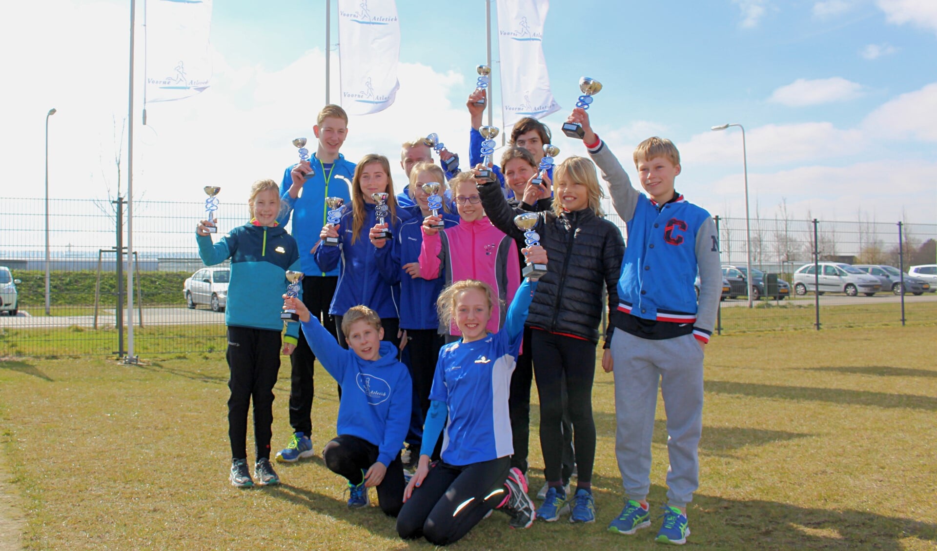 De jonge prijswinnaars van Voorne Atletiek bijeen met de behaalde trofeën.