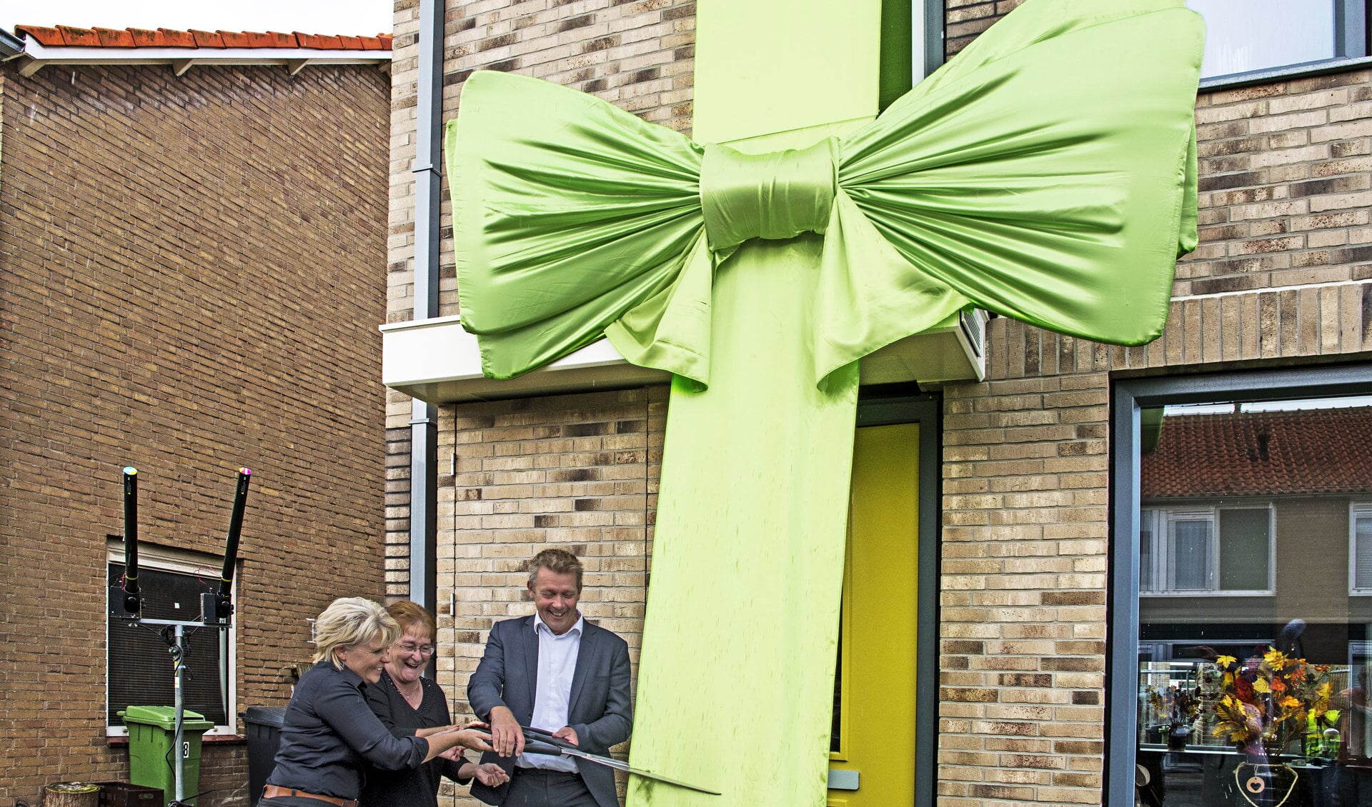 Wethouder van der Meij kreeg hulp van de bewoners bij het doorknippen van het enorme lint (Foto: Jos Uijtdehaage) 