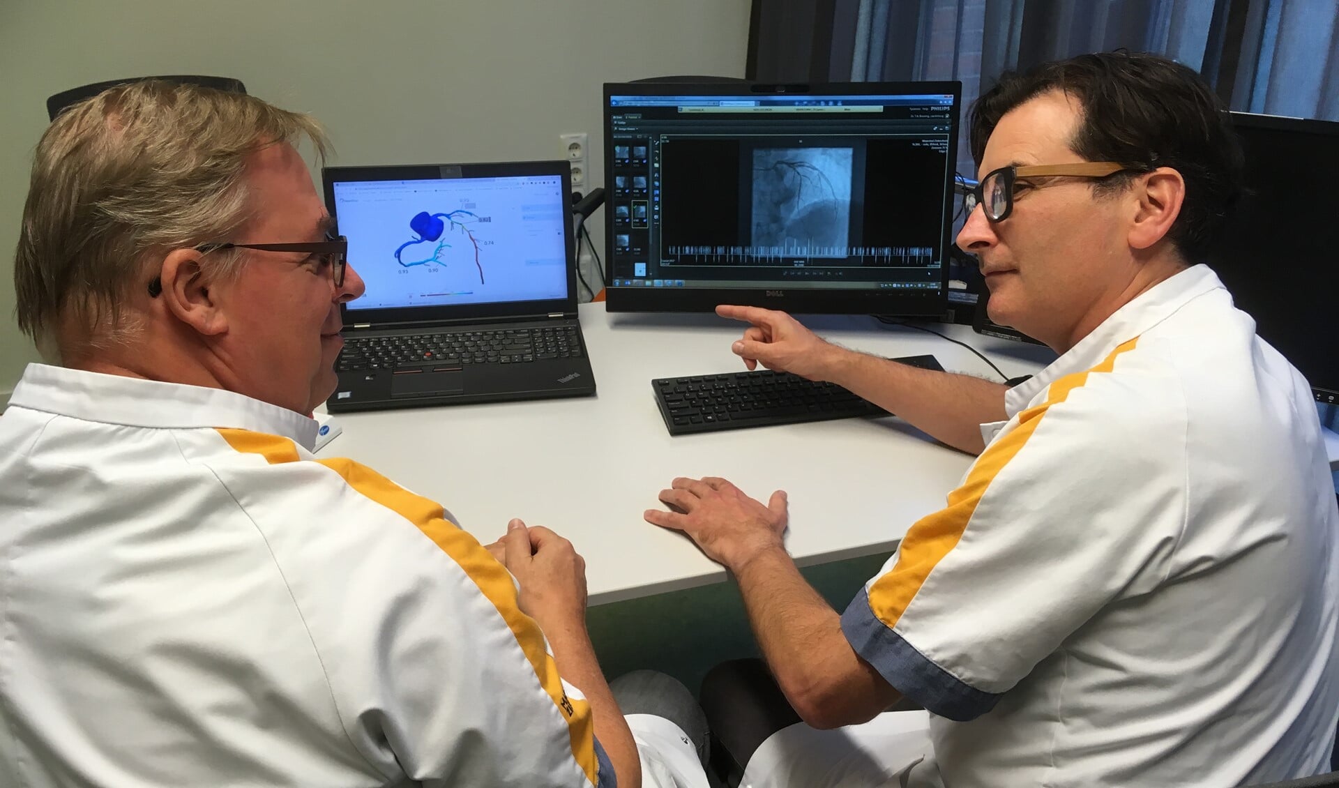 Cardiologen Martin van der Ent (links) en Tobias Bruning (rechts) bespreken de virtuele FFRanalyse (beeldscherm links)