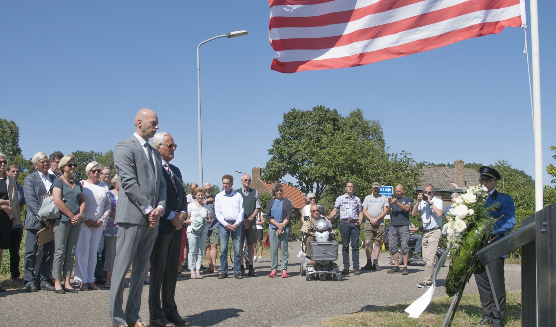 n een stille tocht liep men naar de herdenkingsplaquette waar Notenboom en Den Hollander een krans plaatsten en waar aan twee masten de vlaggen van Amerika en Nederland waren bevestigd. (foto: Jan Baks)