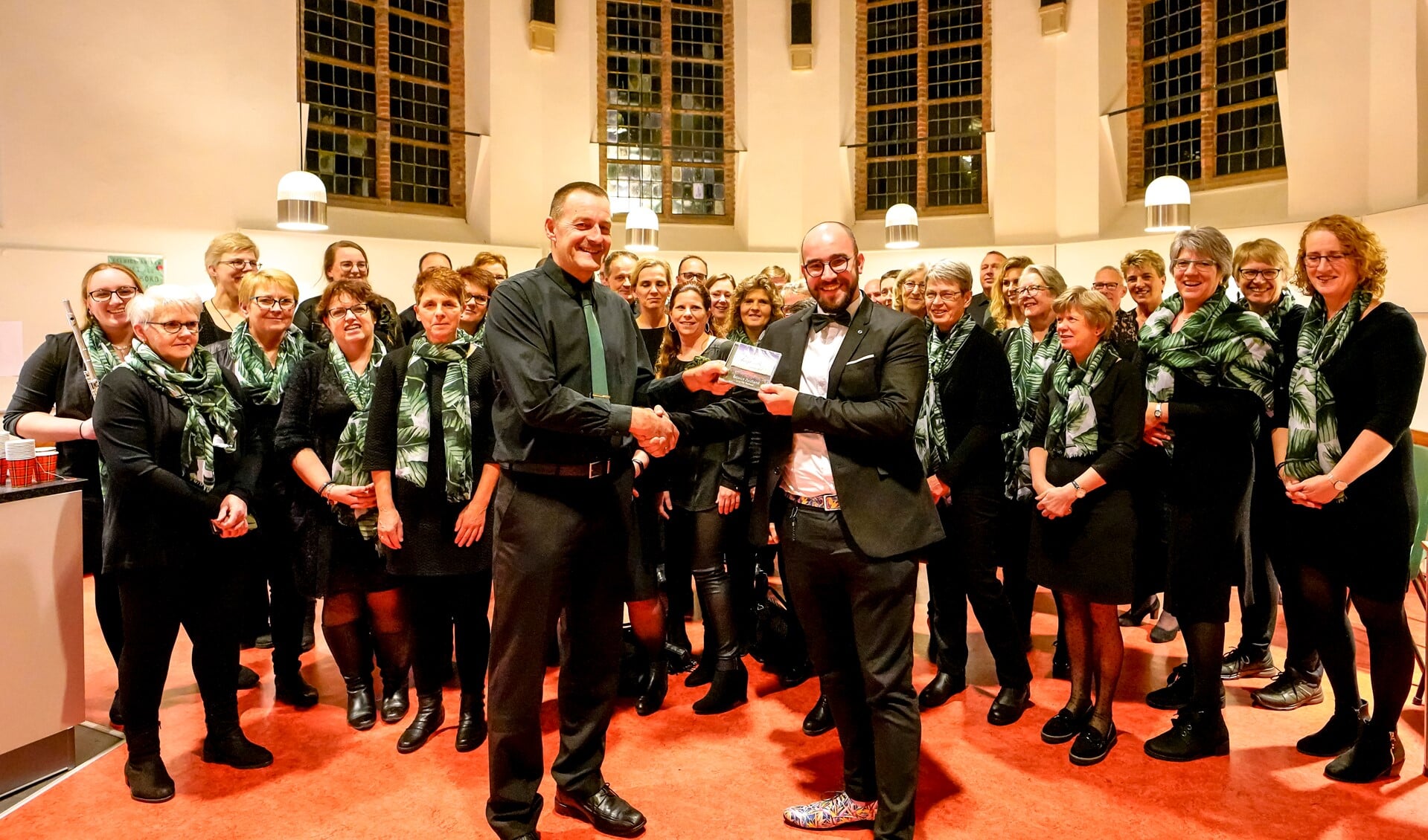 Rejoice voorzitter Henk van der Kaa overhandigde de cd aan dirigent Flip Markwat (r).