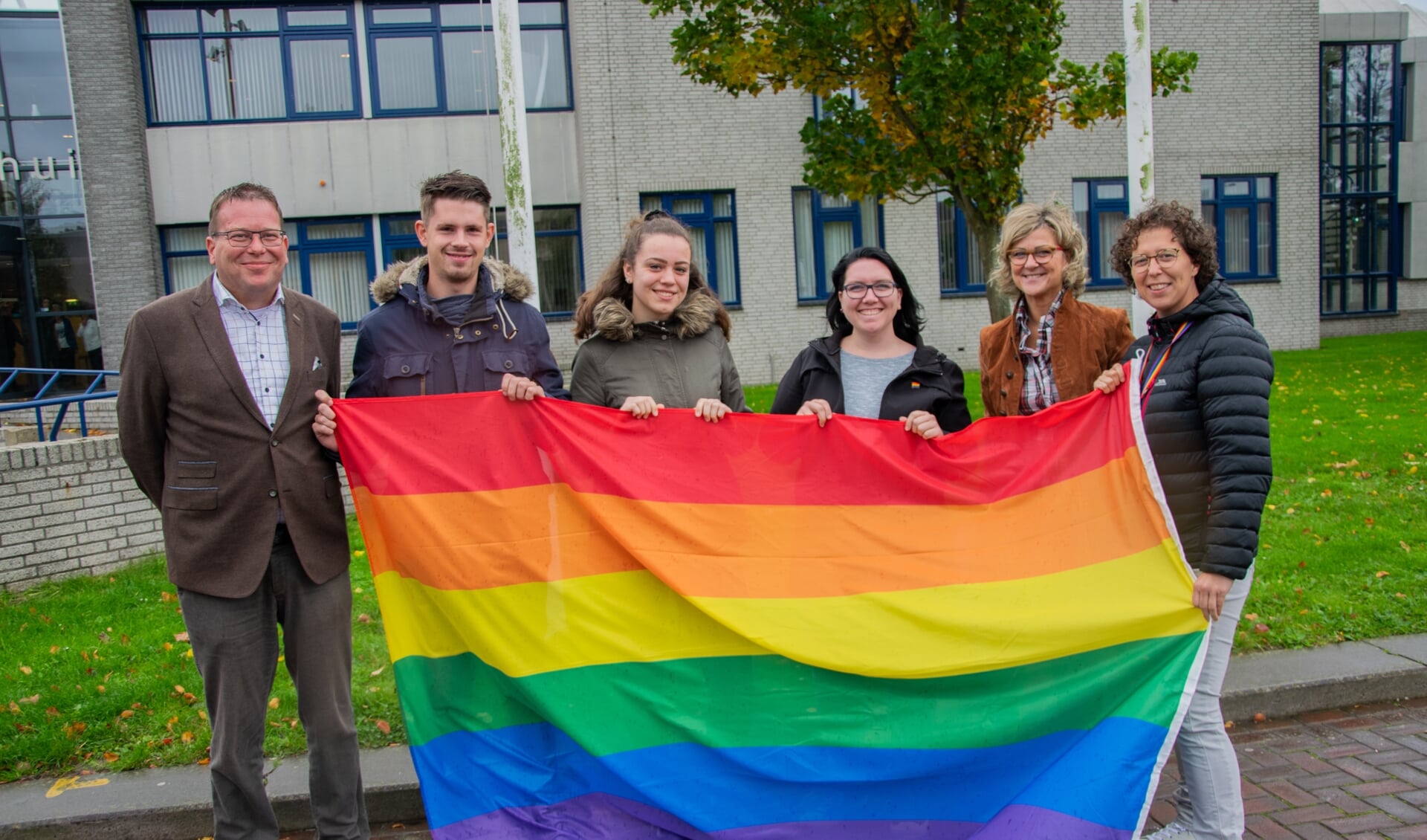 Stichting Gay op Flakkee hijst bij het gemeentehuis de vlag met burgemeester Grootenboer en wethouder Bruggeman.  Foto: Sam Fish