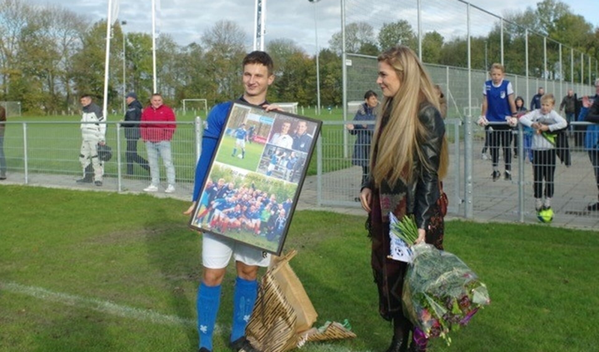 Jubilaris Tim Mackloet ontving een fotocollage. links van hem zijn vriendin Rianne van Meurs.