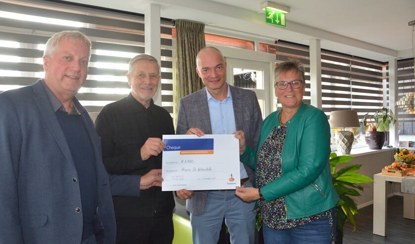 Jacob den Bakker (links) en Cees Engbers (2e van rechts) overhandigen de cheque aan vertegenwoordigers van De Waterlelie.