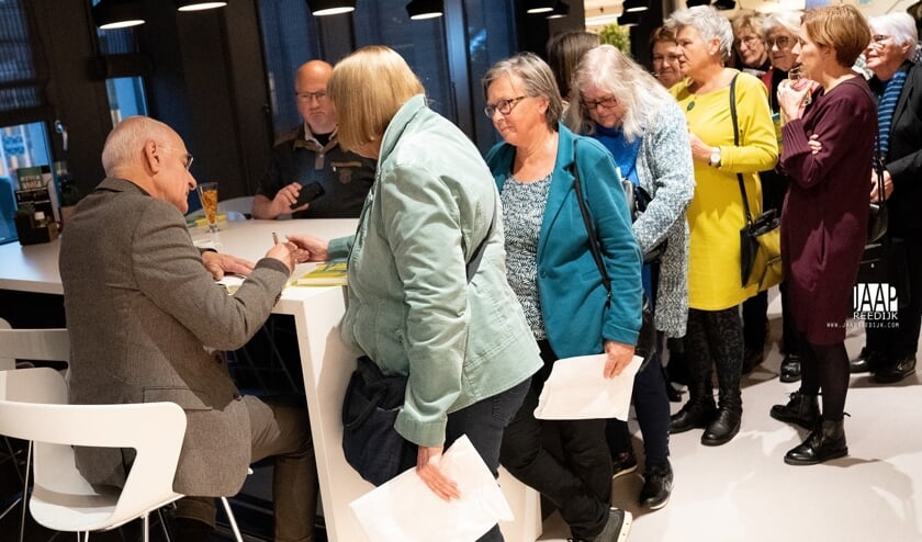 Frits Spits signeert zijn boek.