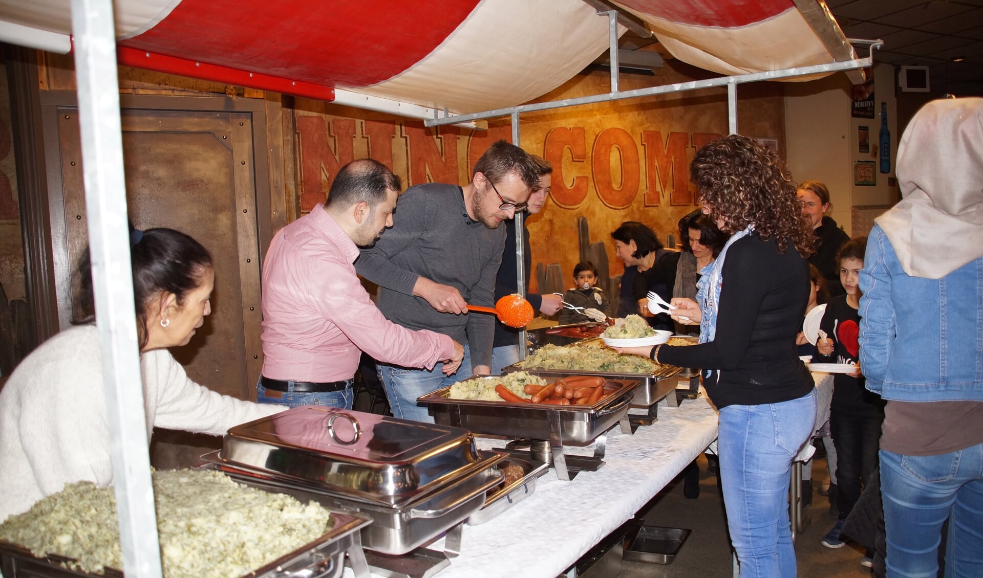 Het eten werd verzorgd door Hussam Karkas (in roze overhemd) met zijn vrouw, die drie jaar geleden vanuit Syrië naar Nederland kwamen. Hij gaat trouwens aan de slag als kok in het restaurant van WSW Ouddorp. 