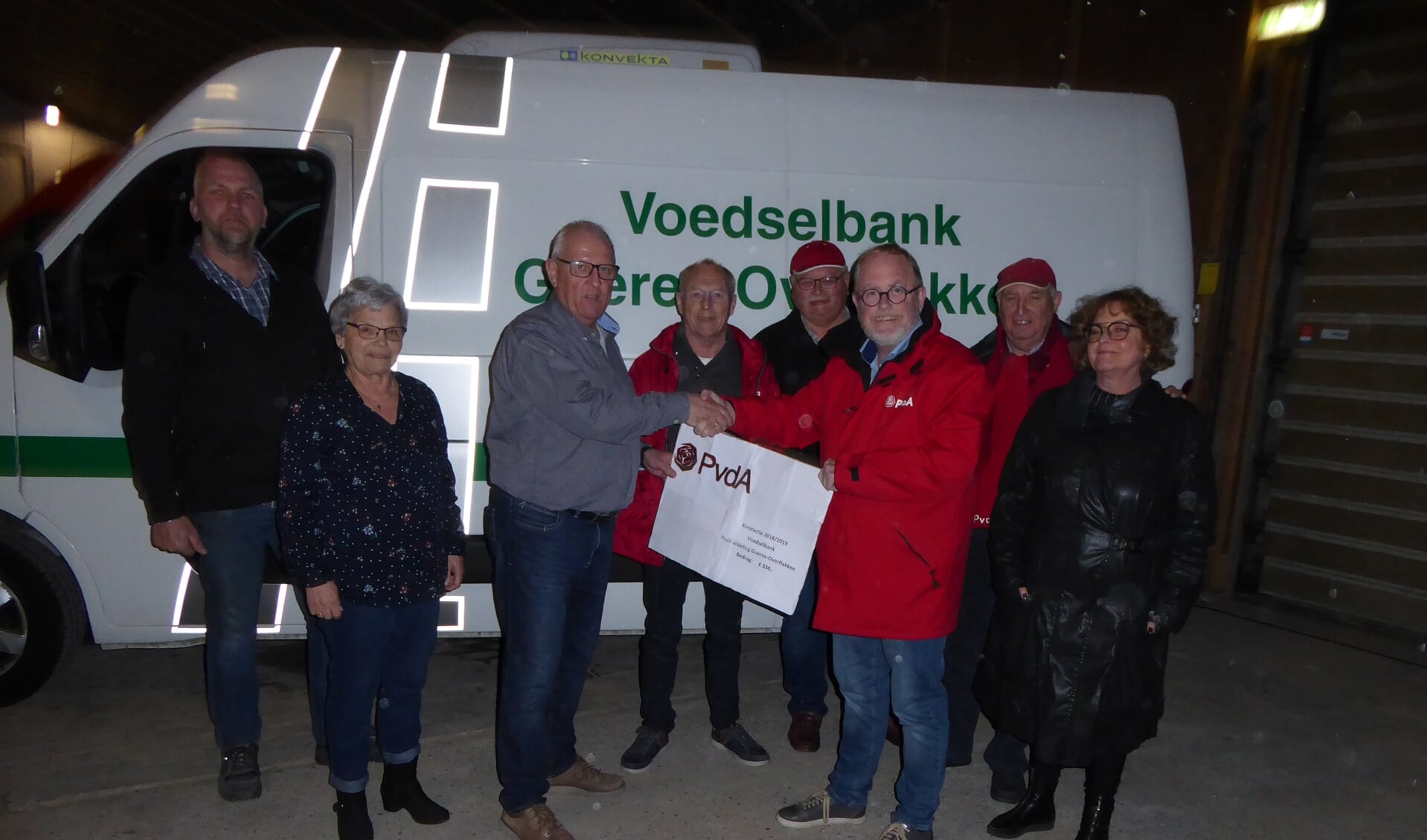 Penningmeester van de Voedselbank, Martin Ista, neemt de cheque van fractievoorzitter Jaap-Willem Eijkenduijn in ontvangst.