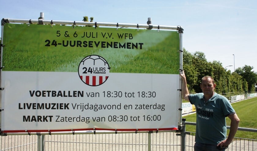 Leon Struijk, één van de organisatoren, bij het reclamebord van het 24-uurs toernooi.