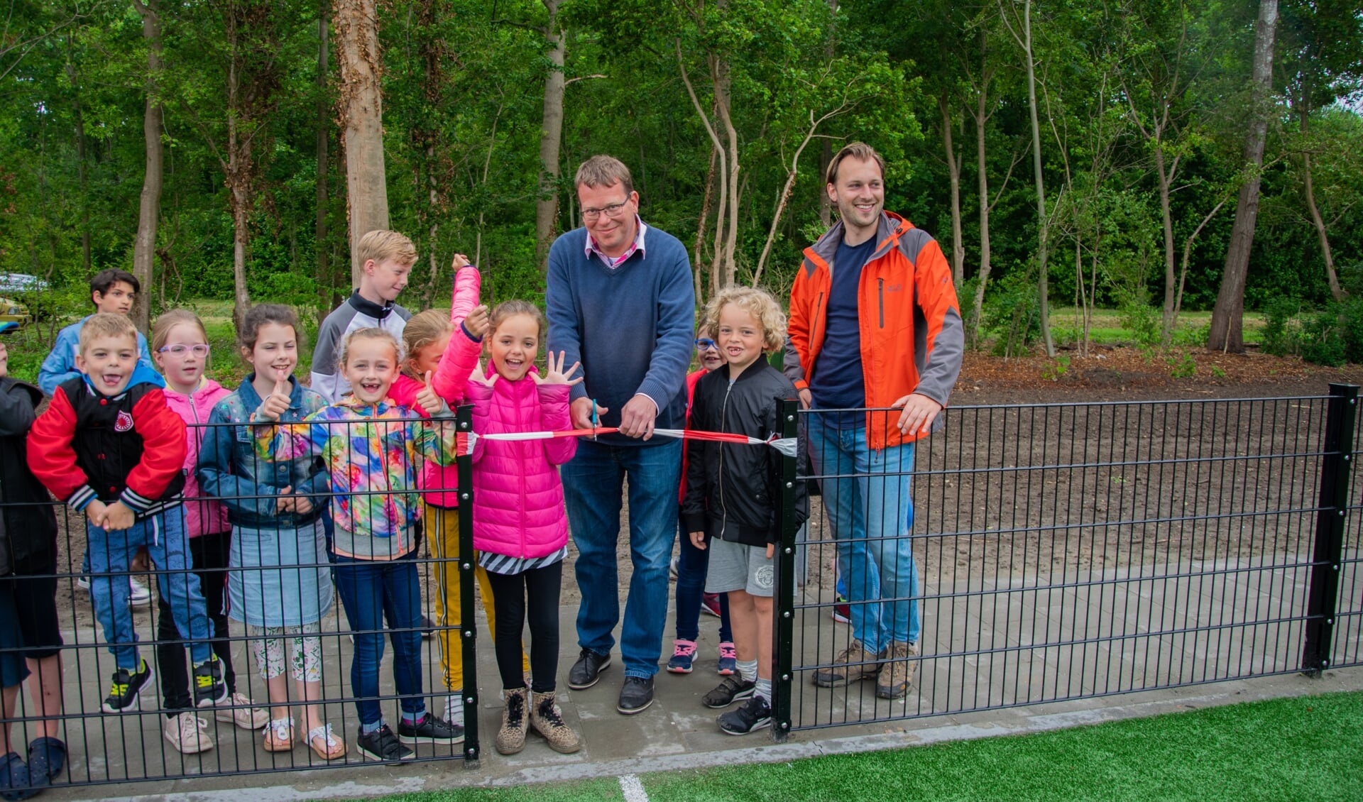 Wethouder Bruggeman mocht het lint doorknippen zodat de kinderen officieel gebruik kunnen maken van de sportkooi.  Foto: Sam Fish