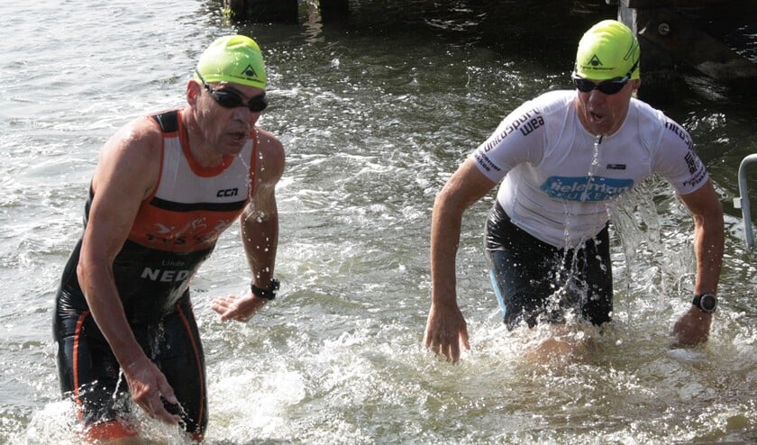 Nico Paasse (rechts) als één van de eerste uit het water na 1000 meter zwemmen. (Foto Fred Götzenberger)