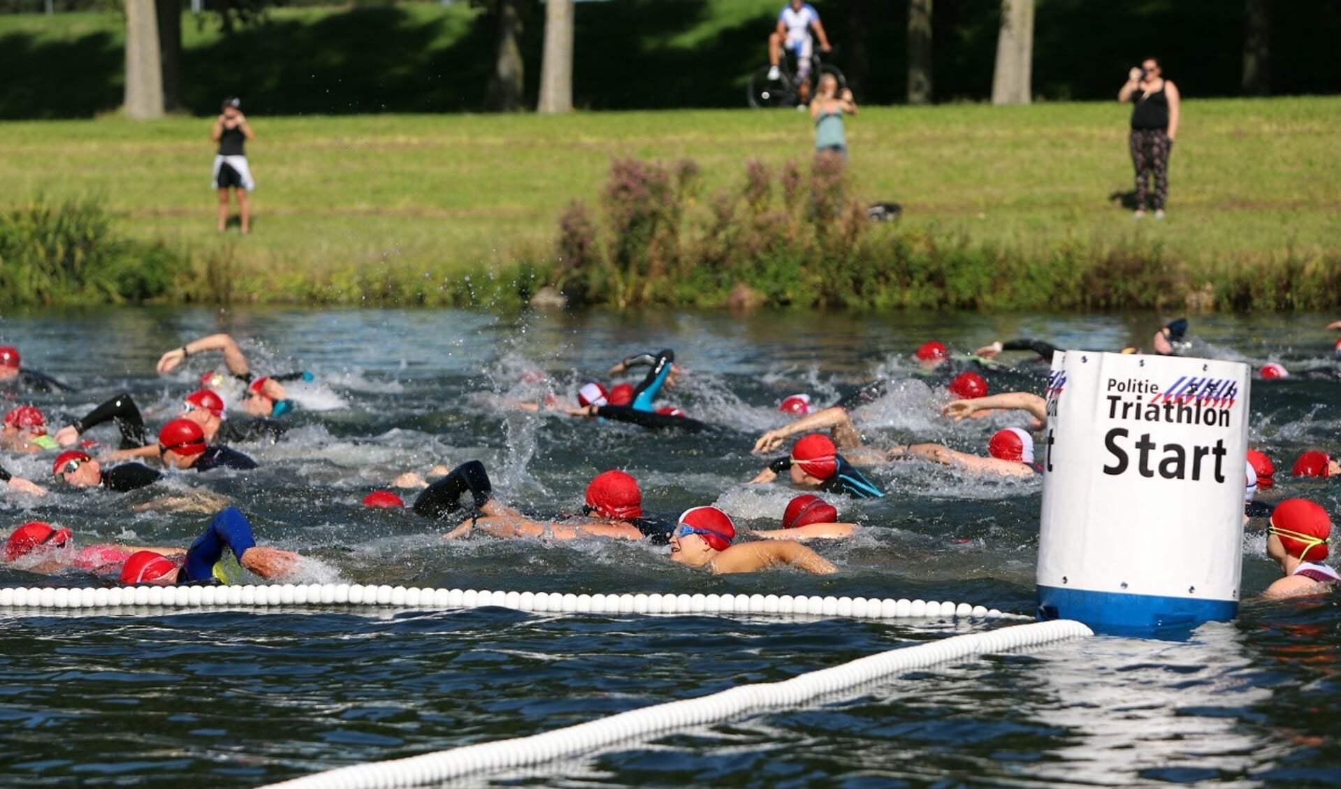 De deelnemers aan de triathlon van Spijkenisse startten met anderhalve kilometer zwemen in het Hartelkanaal. Fotografie Peter de Jong