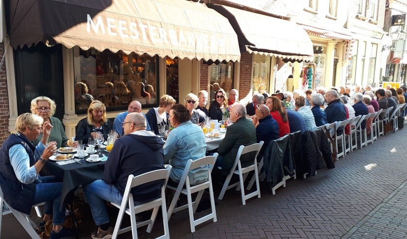 Met zijn allen gezellig aan een lange tafel in de zon!