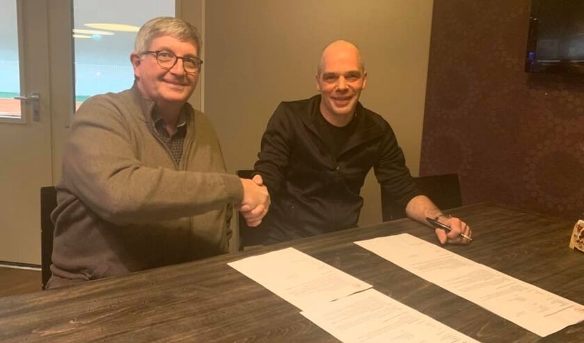 Voorzitter Jan de Leeuw (links) en Petri van Dijk bevestigen de verlenging met een handdruk. Van Dijk blijft nog een seizoen bij Good Luck.