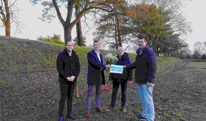 Wethouder Daan Markwat (met bloemen) overhandigt symbolisch de subsidie aan Teunis Aleman (helemaal rechts).
