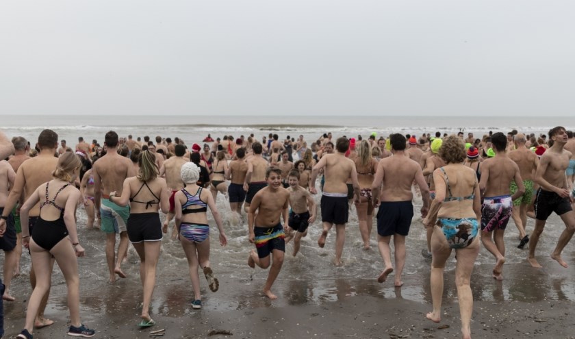 Honderden mensen renden de zee in voor de Nieuwjaarsduik.