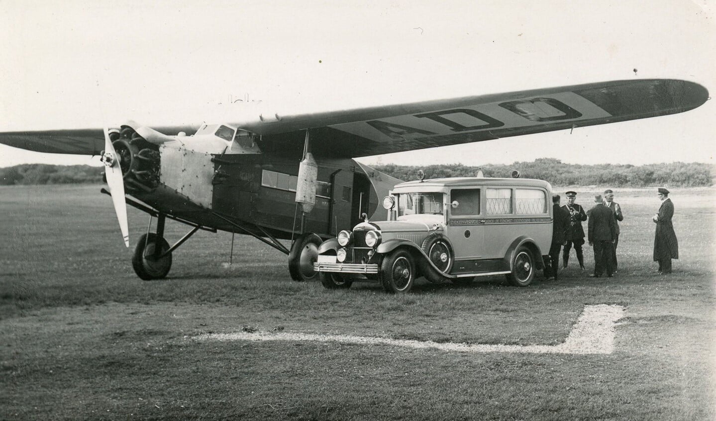 De ambulance, een Cadillac, met daarnaast o.a. veldwachter Lagendijk, dokter Kroes en de piloot Adriaan Viruly op het vliegveld van Oostvoorne (Foto: collectie Hans Waldeck - Nederlands Ambulance Archief)