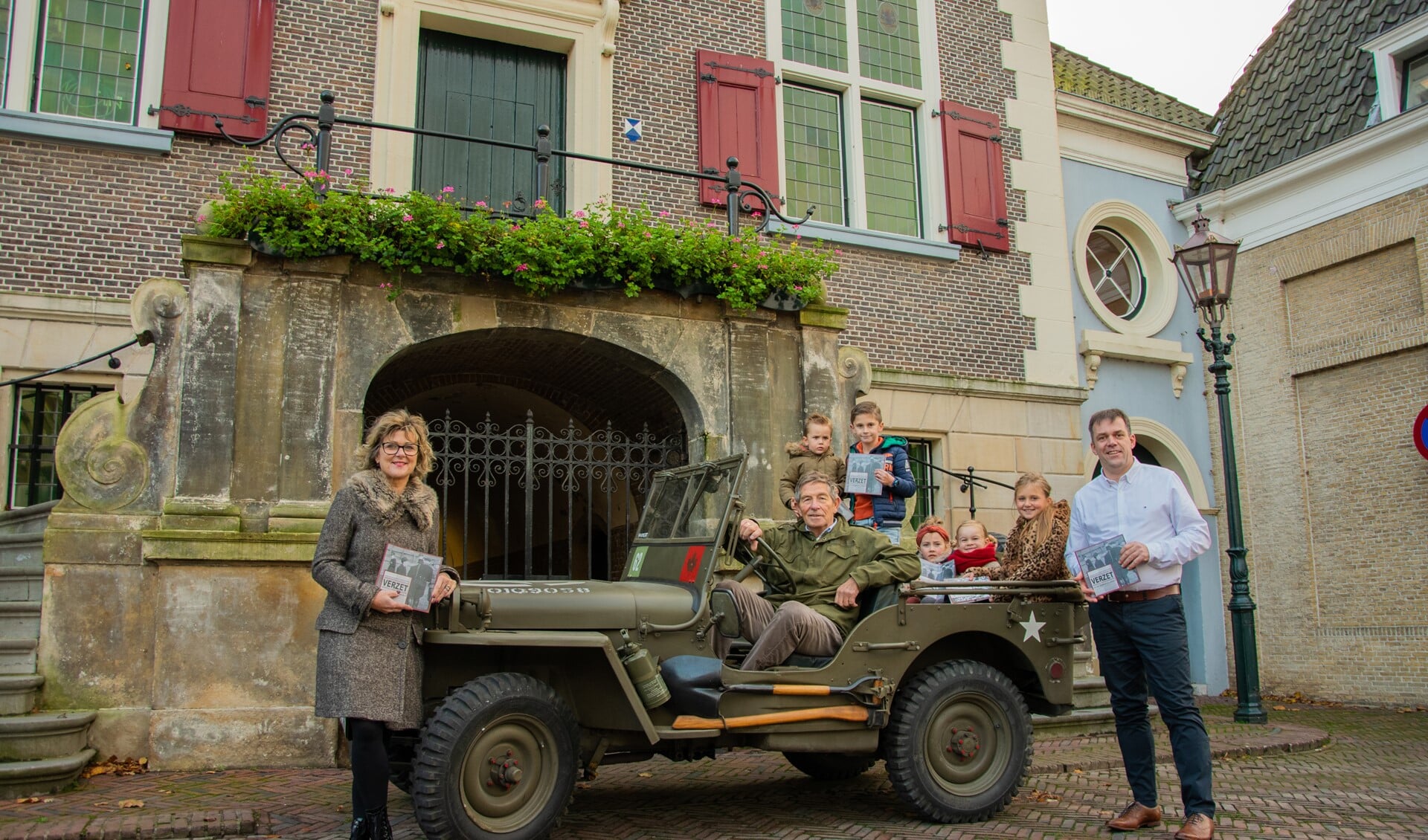 De overhandiging van het boekje gebeurde op bijzondere wijze bij het oude Raadhuis in Middelharnis, met een oude oorlogsjeep en blije kinderen.  Foto: Sam Fish