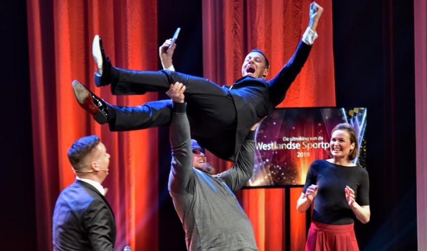 Presentator Jeroen Toet wordt onder toeziend oog van handbalcoryfee Yvette Broch gelift door Sebastiaan Tempelaars, 'Sportman van het jaar 2019'.