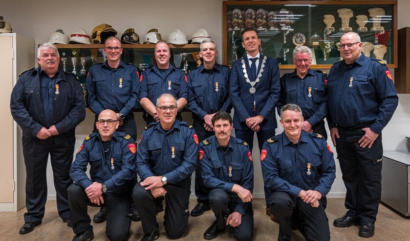 Locoburgemeester Daan Markwat speldde in Dirksland bij tien brandweerlieden een Koninklijke onderscheiding op.