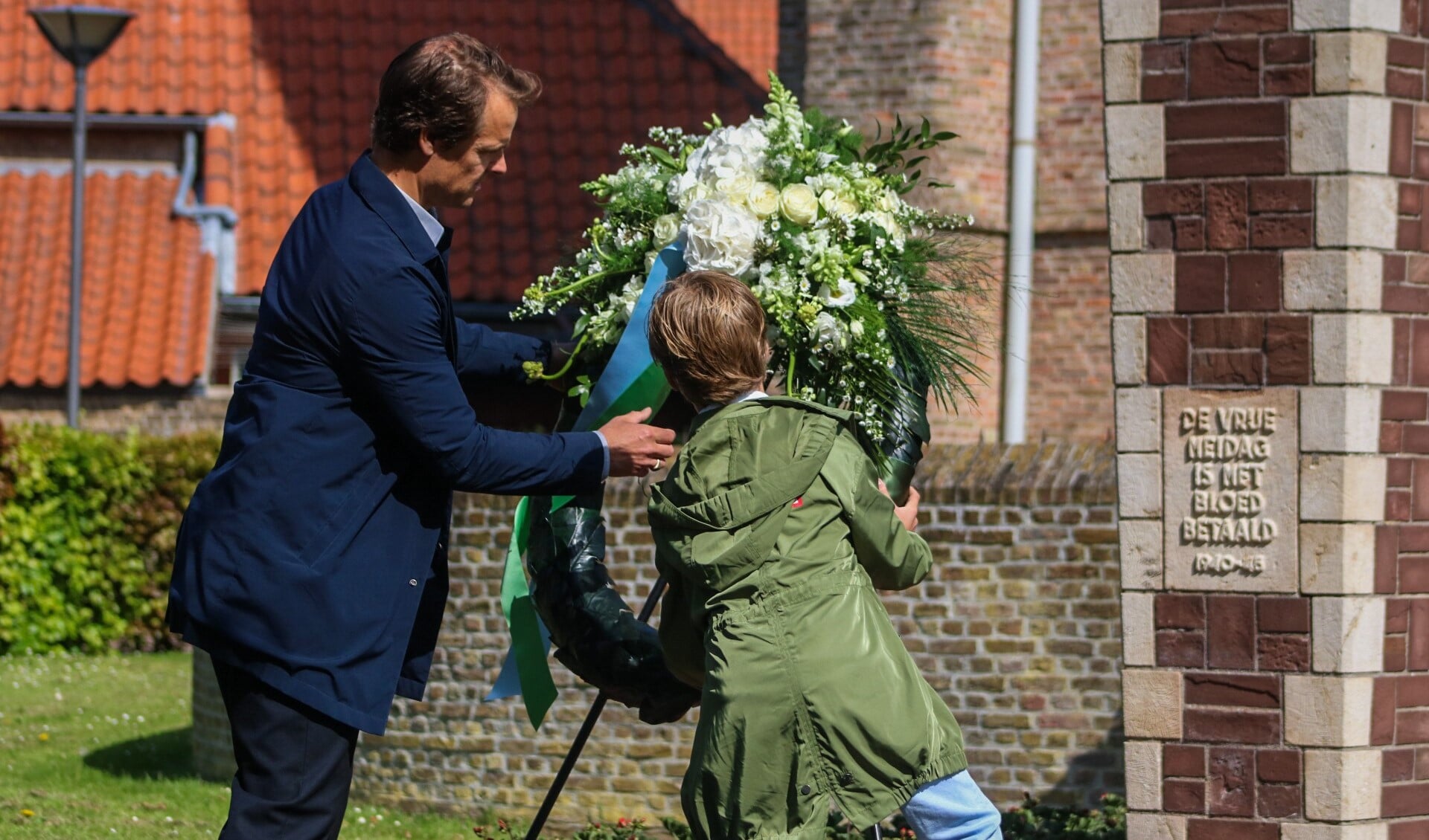 Wethouder Hamerslag en zijn zoon lagen een krans in Zuidland. Fotografie: Martijn de Bruijn/ Jolanda Voogd.