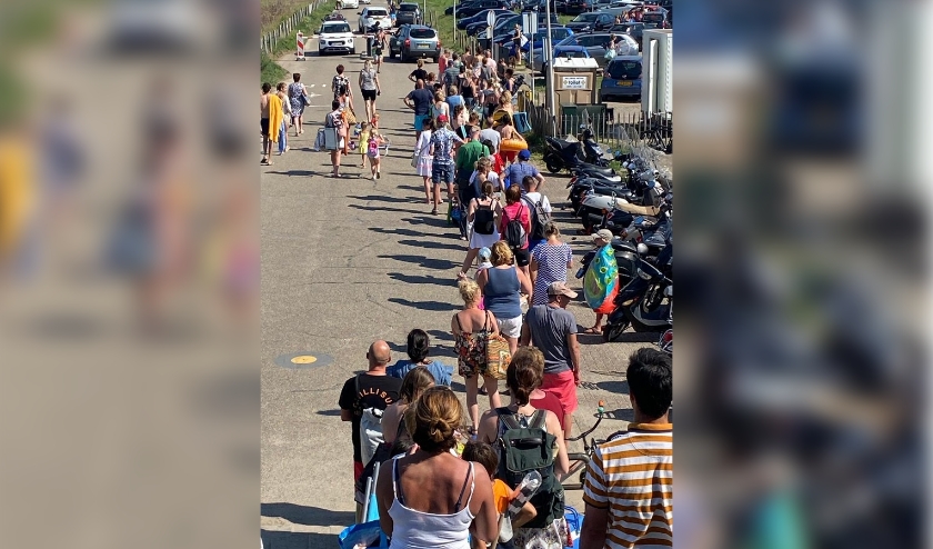Een enorme rij van wachtende mensen bij de parkeerautomaat bij het strand van Molenslag in Monster. Foto: (Remmert Keizer)