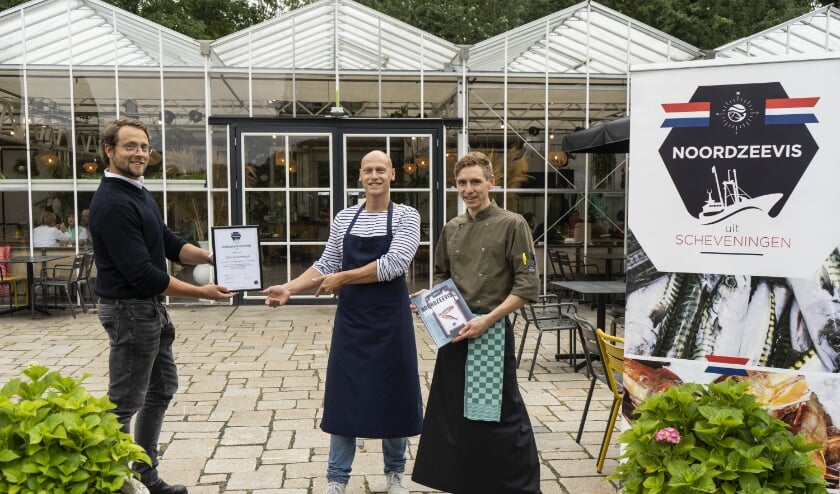 Matthijs den Heijer, bestuurslid St. Noordzeevis, overhandigt de oorkonde aan Vincent Slot (bedrijfsleider) en Leon in ’t Hout (chef-kok). Foto: (PR)