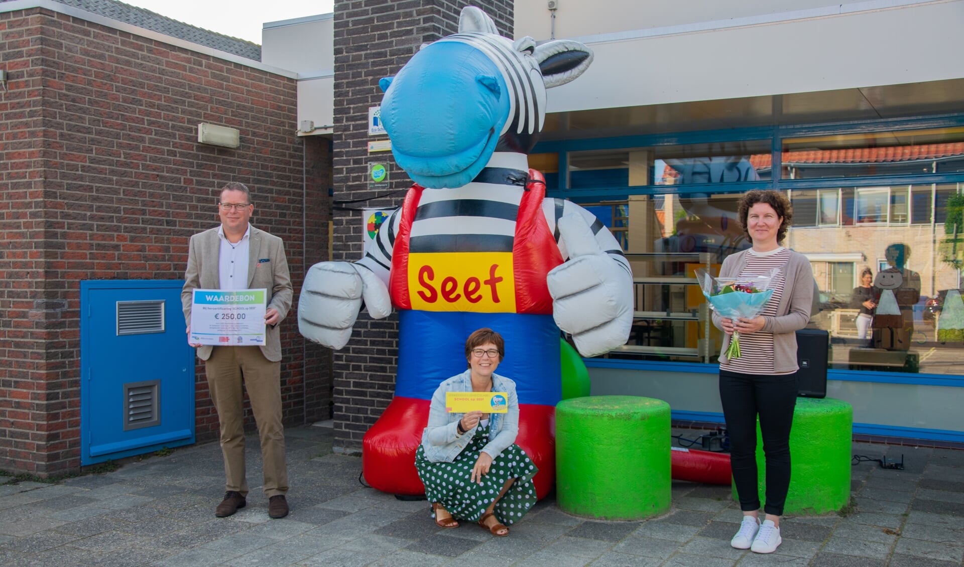 Een nieuw bordje voor naast de deur, een cheque van 250 euro en natuurlijk een bloemetje voor de verkeersmoeder. Obs Roxenisse is weer hartstikke veilig!  Foto: Sam Fish