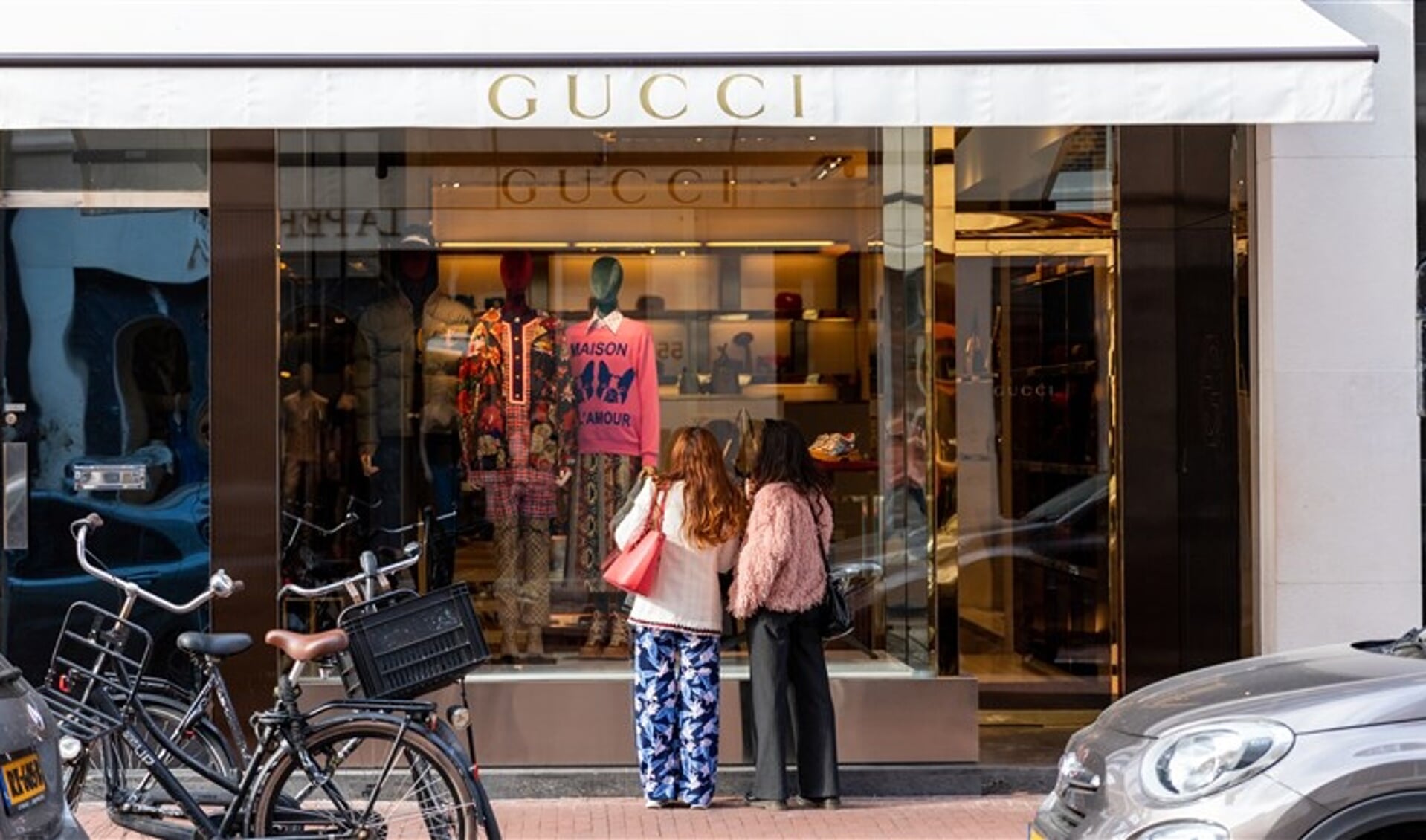 Twee dames die voor de etalage van de Gucci winkel in de PC Hooftstraat staan.