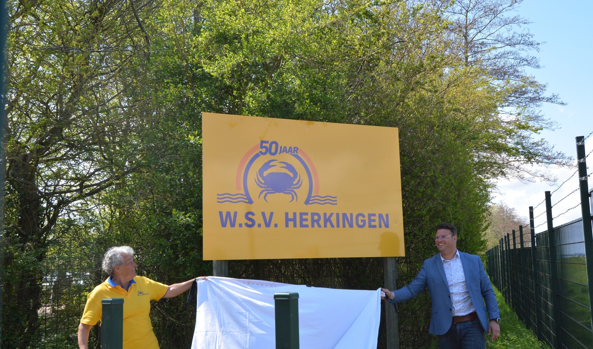 Vijftig jaar WSV Herkingen. Het bord aan de ingang van het terrein werd onthuld door Loes Oranje, voorzitter jubileumcommissie, en Harmen van Dorsser, voorzitter WSV.
