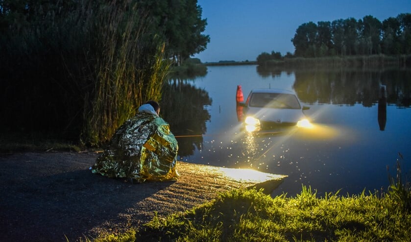 <p>Met een touw voorkwam de eigenaar dat de auto verder het water in rolde. </p>