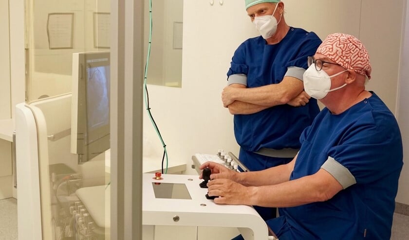 <p>Cardiologen Van der Ent (r) en Smits (l) met de nieuwe R-One robot.</p>