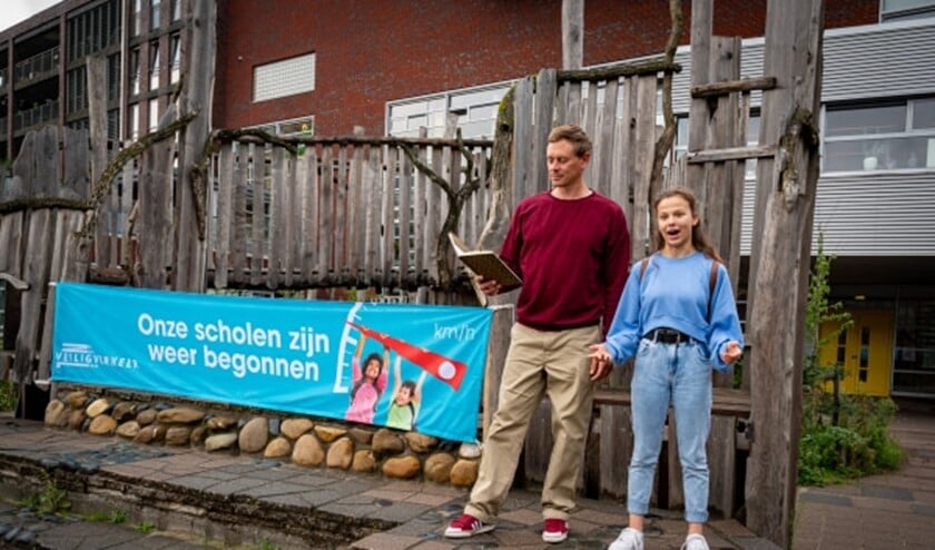 Justin Samgar en scholier Anna dragen het gedicht “Onze scholen zijn weer begonnen” voor bij basisschool de Hasselbraam in Amsterdam