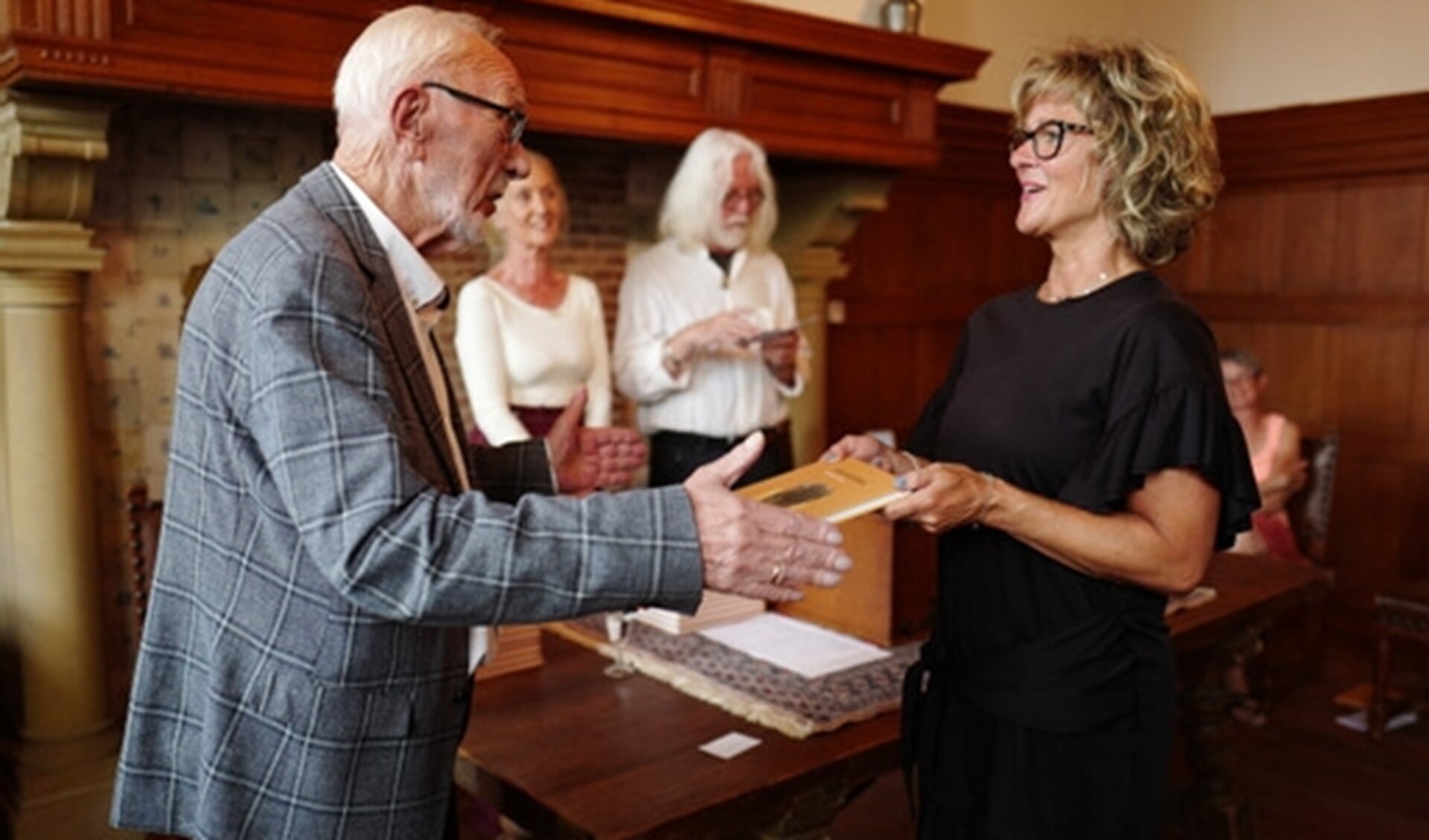 Henk reikt het boek uit aan burgemeester Ada Grootenboer!
