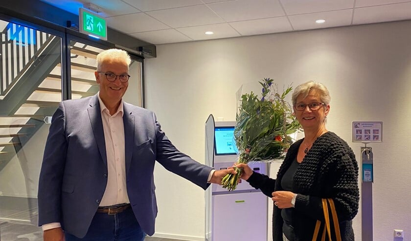<p>Bestuurder Koos Moerland van Het Van Weel-Bethesda Ziekenhuis overhandigt bos bloemen aan eerste patiënt mevrouw Buijs </p>